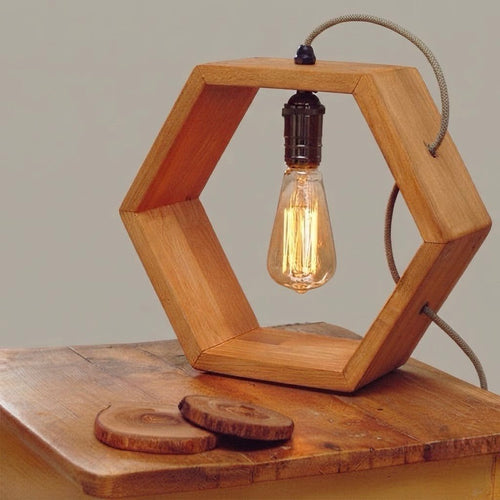 Hexagonal wood frame table lamp with Edison bulb.